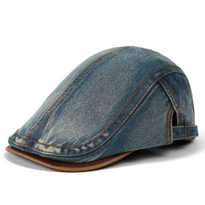 Detail of vintage denim flat cap featuring orange stitching and adjustable metal buckle