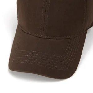 Detailed close-up of parallel stitching on dark brown cotton canvas baseball cap brim