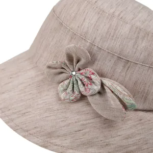 Detail of summer sun hat featuring floral fabric bow ornament and textured cotton weave