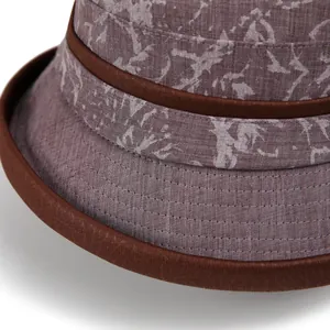 Close-up of violet bucket hat showing precise stitching and brown decorative trim details