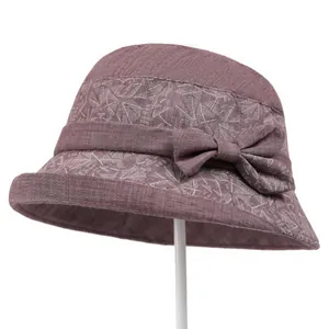 Detail of pink elder women fisherman hat with white leaf patterns and side bow decoration