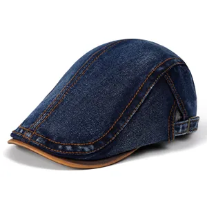 Detail of vintage denim cap showing washed blue fabric and brown leather brim edges