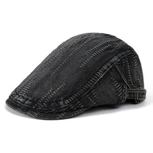 Detail view of washed denim flat cap with adjustable copper buckle and contrast stitching