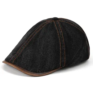 Detailed shot of black denim beret with brown leather trim and contrast stitching