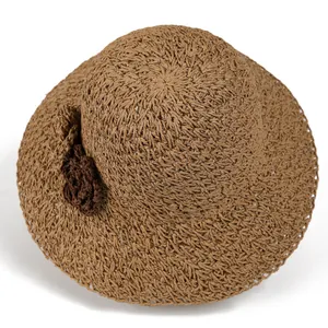 Brown woven straw beach hat with decorative flower and wide brim for sun protection