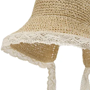 Straw sun hat for women with white lace trim and wide ribbons for summer beach travel