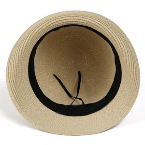 Interior view of natural straw sun hat showing fine weave texture and black adjustable strap
