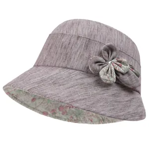 Detail of purple cotton sun hat featuring fabric flower ornament and rhinestone core