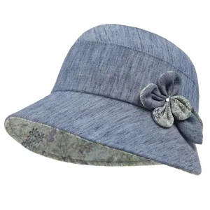 Detailed view of women's sun hat featuring fabric flower with rhinestone and floral lining