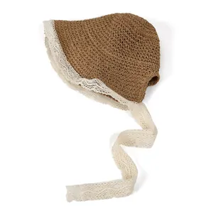 Close-up of brown woven straw texture and delicate off-white lace trim on the sun hat