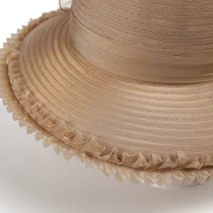 Détail du chapeau de soleil en organza champagne avec rubans superposés et bordure ondulée