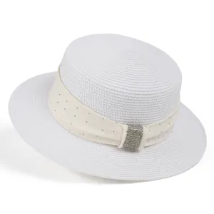 Close-up of white straw hat with elegant mesh ribbon and sparkling rhinestone buckle detail