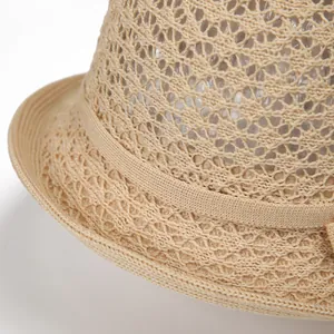 Close-up of the delicate hollow woven mesh texture on this stylish khaki straw hat
