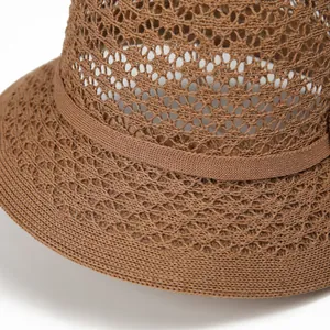 Detailed close-up of brown woven sun hat showing intricate floral crochet and breathable mesh