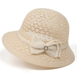Detail of beige crochet sun hat with bow decoration and pearl rhinestone embellishment