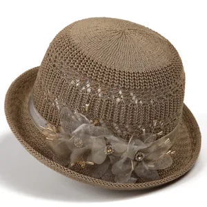Detail of British style sun hat featuring mesh flowers, ribbon, and rhinestone accents