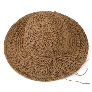 Detail of hollow woven straw hat with wide brim and decorative ribbon bow for beach
