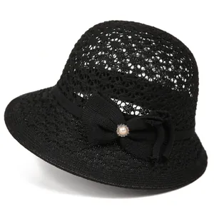 Close-up of black crochet lace sun hat with large bow and pearl accent detail