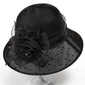 Close-up of black organza sun hat with mesh veil featuring heart dots and a fabric rose