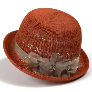 Detail of caramel braided sun hat showing handcrafted flowers with rhinestone accents