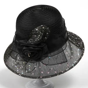 Detail of elegant black organza sun hat with sequins and a large 3D floral decoration