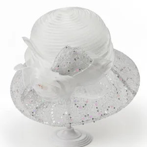 Close-up of elegant white organza sun hat with mesh sequins and floral decoration