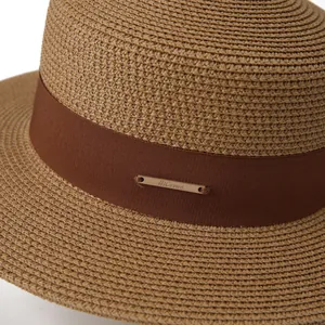 Women's khaki straw sun hat with elegant brown ribbon and decorative gold metal plate