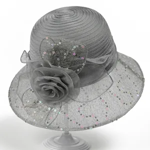 Detail of grey organza hat featuring a large 3D silk flower and colorful sequins