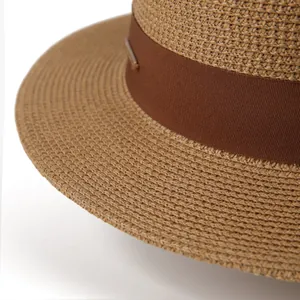 Close-up of the fine woven straw texture and dark brown ribbon on a boater hat