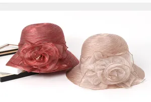 Detail of elegant sun hats with large organza flowers and delicate pearl accents