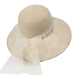 Elegante cappello di paglia beige con nastro in rete e perle per vacanze al mare