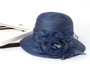 Detail of navy blue organza sun hat featuring a large floral ornament with pearls