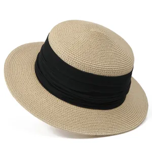 Détail d'un chapeau de paille tressé avec ruban en tissu noir plissé élégant