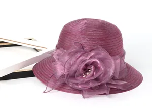 Detail view of burgundy organza sun hat featuring a large handmade flower and pearls