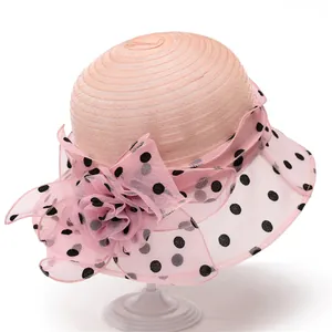 Detailed view of pink sun hat with organza floral accent and black polka dots
