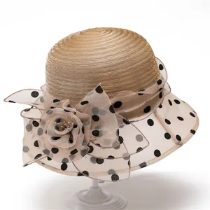 Detailed view of the woven sun hat featuring organza flower with black polka dots