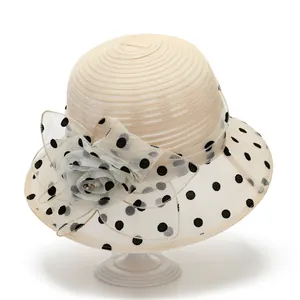Detail of elegant beige sun hat featuring organza rose and black polka dot mesh trim