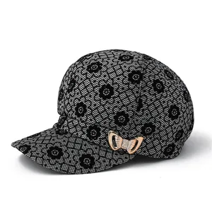 Détail du tissu en dentelle florale avec paillettes et boucle noeud doré sur la casquette