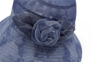 Macro detail of dark blue mesh sun hat featuring an elegant fabric rose decoration