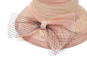 Détail d'un chapeau de soleil rose élégant avec fleur en organza et voile en résille