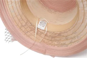 Détail de la doublure du chapeau de soleil rose avec étiquette 100% fil et protection UV