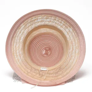 Détail de l'intérieur d'un chapeau de soleil en organza rose avec voile en maille noire