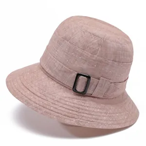 Detailed close-up of pink bucket hat featuring white micro dots and black side buckle