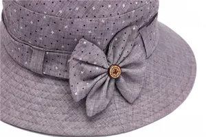 Détail d'un chapeau de soleil violet à pois avec un nœud et un bouton en bois rétro