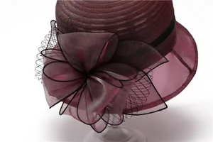 Detail of burgundy organza flower and black mesh on elegant sun hat for women