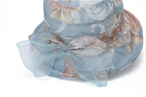 Detailed view of women's sun hat with floral pattern and large organza bow decoration