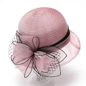 Pink organza sun hat featuring an elegant large bow and black mesh veil detail