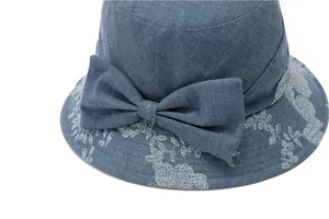 Detail of blue sun hat for women featuring delicate floral embroidery and a bow accent