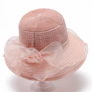 Detail of elegant peach organza bow and floral embellishments on a sun hat