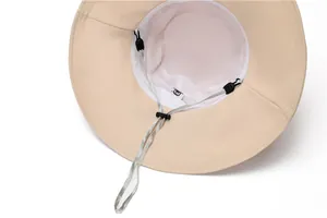 Detail view of breathable mesh lining and adjustable windproof strap on beige sun hat